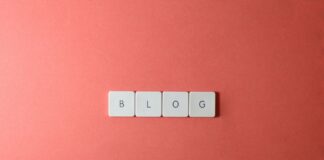 Klawisze klawiatury układające się w napis BLOG na koralowym tle