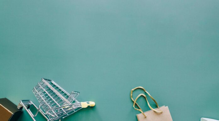 Kampanie produktowe kontra kampanie wizerunkowe w e-commerce: jak je łączyć Wózek i torba zakupowa na niebieskim tle widziane z góry