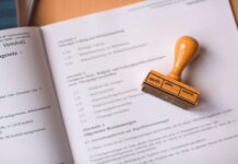 Reklama cenowa w e‑commerce po dyrektywie Omnibus: co musi widzieć klient Zbliżenie na dokument prawny z drewnianą pieczątką weryfikacyjną