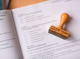Zbliżenie na dokument prawny z drewnianą pieczątką weryfikacyjną