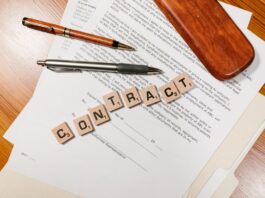 Zbliżenie na dokumenty umowy i płytki Scrabble z napisem CONTRACT