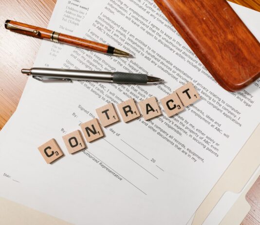 Zbliżenie na dokumenty umowy i płytki Scrabble z napisem CONTRACT
