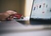 Certyfikat SSL w sklepie internetowym: jakie daje realne korzyści Osoba trzyma kartę płatniczą podczas zakupów online na laptopie
