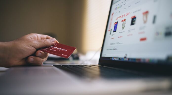 Certyfikat SSL w sklepie internetowym: jakie daje realne korzyści Osoba trzyma kartę płatniczą podczas zakupów online na laptopie